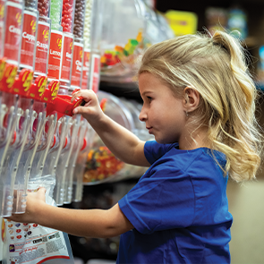 Young girl filling up a bag of candy